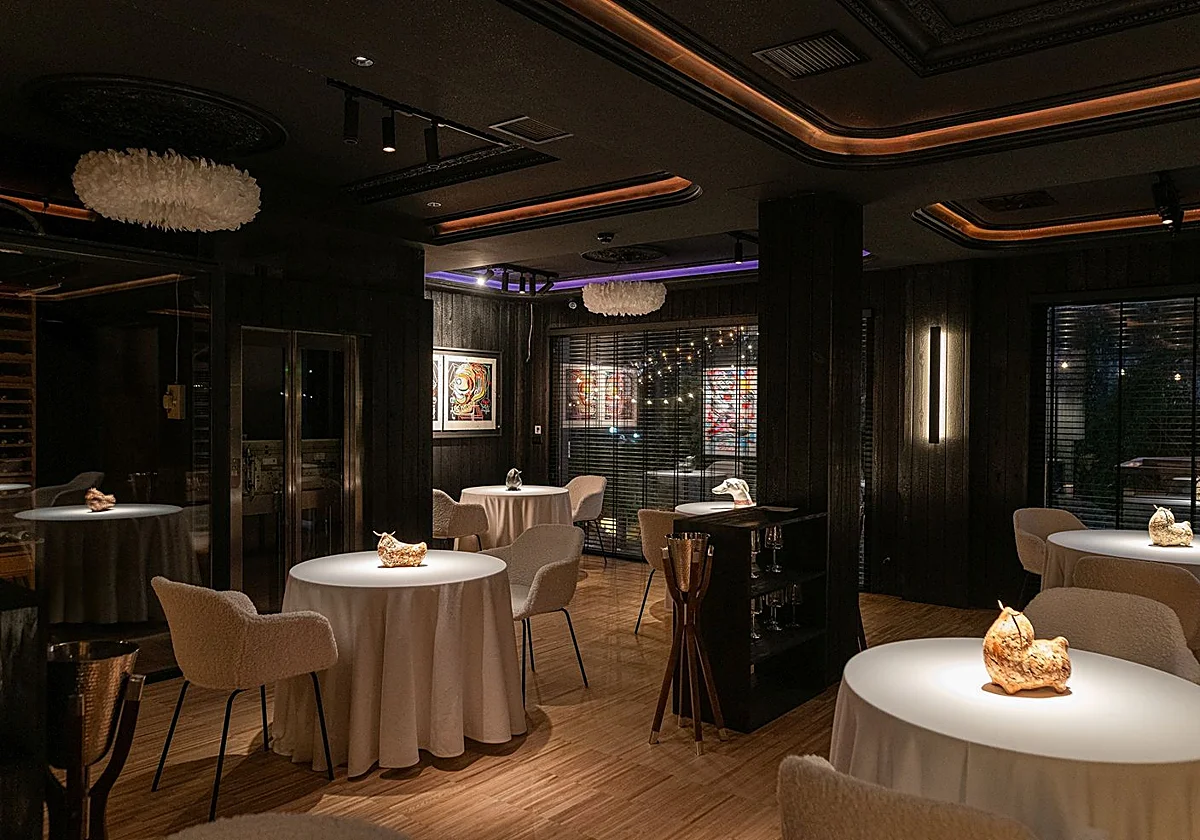 Comedor de Ancestral Restaurante, con mesas redondas y luz tenue